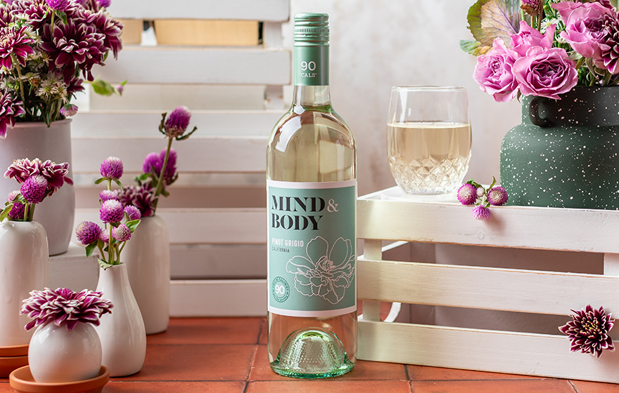 bottle and glass of mind and bottle pinot grigio surrounded by purple fall flowers